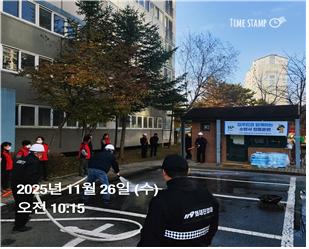 파주새꽃마을3단지에서 겨울철 화재대비 소방서 합동훈련에서 한 입주민이 소화전에 호스를 직접 연결하여 물을 분사하는 과정을 연출하고 있다