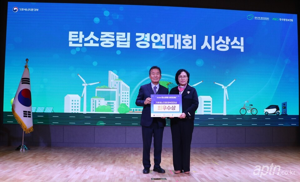‘2025 탄소중립 경연대회’ 시상식에서 인천검단우미린더시그니처 홍라연 관리소장(오른쪽)이 민간부문 기후에너지환경부 장관상 최우수상을 수상한 뒤 시상자와 기념촬영을 하고 있다. [사진=우리관리]