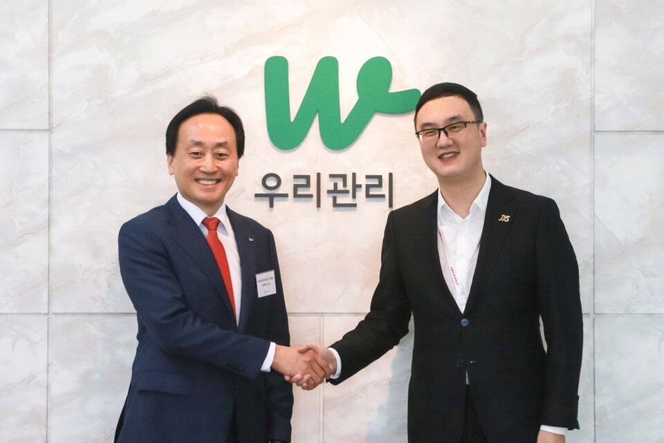 노병용 우리관리 회장(왼쪽)과 샤사오페이 진커스마트서비스 그룹 회장이 악수하고 있는 모습. [아파트관리신문]