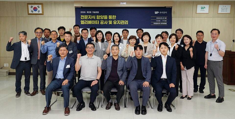 22일 승강기 교체 공사를 주제로 열린 우리관리 ‘2026 제2회 기술포럼’에서 우리관리 김영복 대표이사(앞줄 왼쪽 세 번째)를 비롯한 참석 관리소장들, 현대엘리베이터 관계자 등이 단체사진을 찍고 있다. [사진=우리관리]