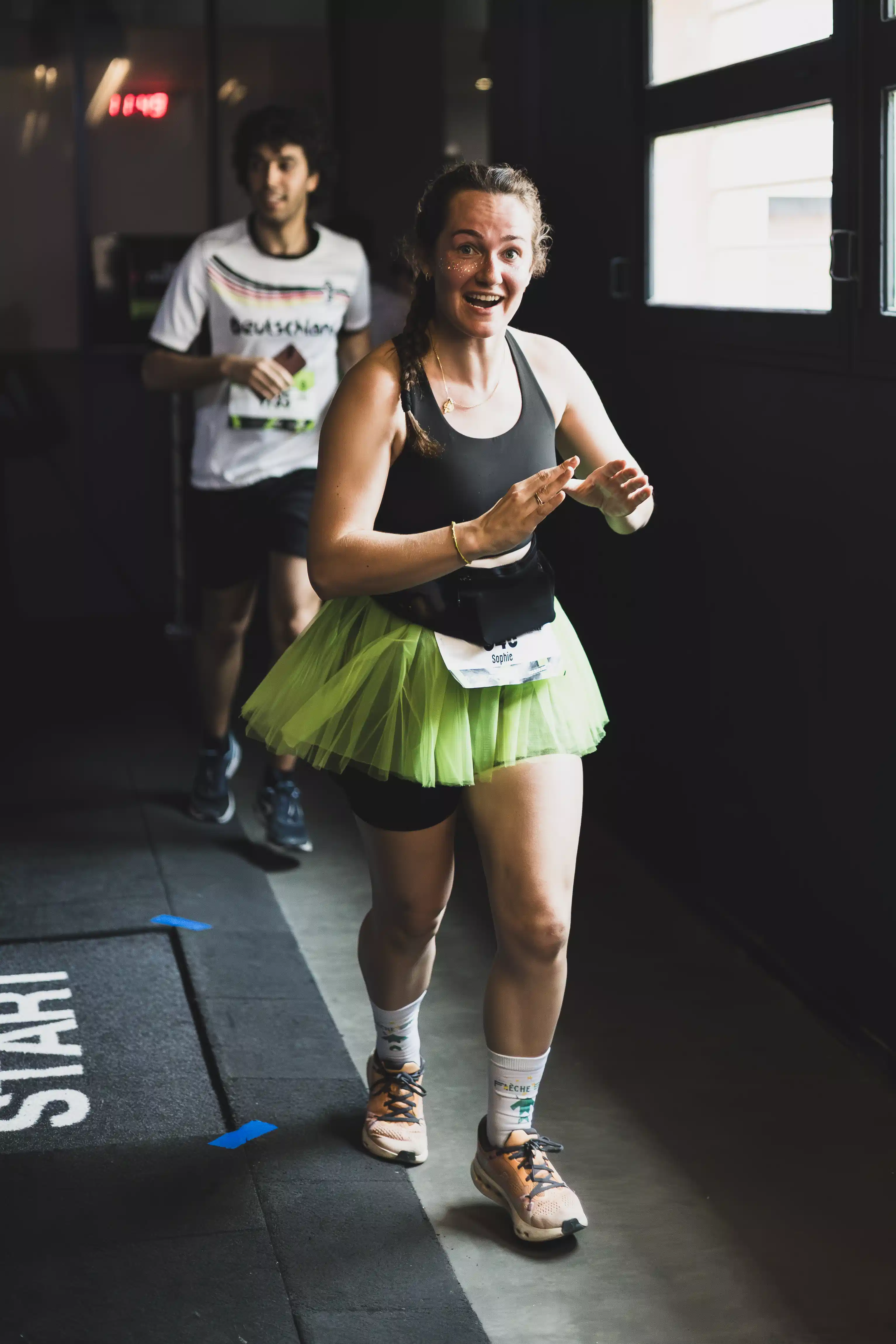 Coureuse souriante en tutu au départ d'une course