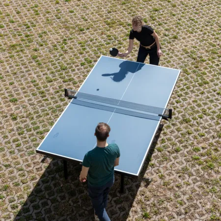 Zwei Agenturmitarbeitende, die zusammen Tischtennis spielen.