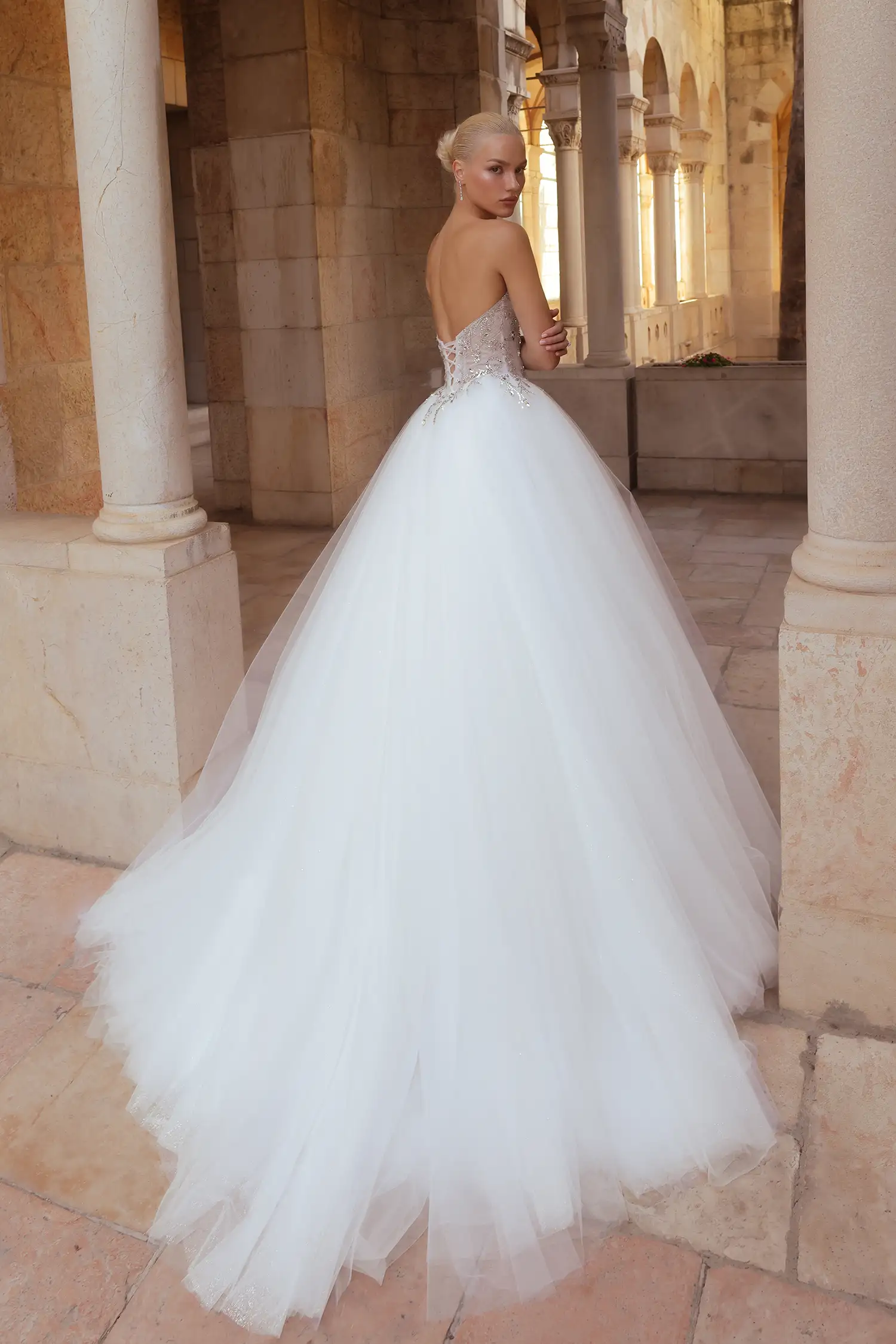 Strapless, sweetheart neckline ballgown with tulle plissé bodice fully embellished in mirror crystals and full tulle skirt with glitter underlay. Shown with sheer tulle gloves with mirror crystal appliqué.