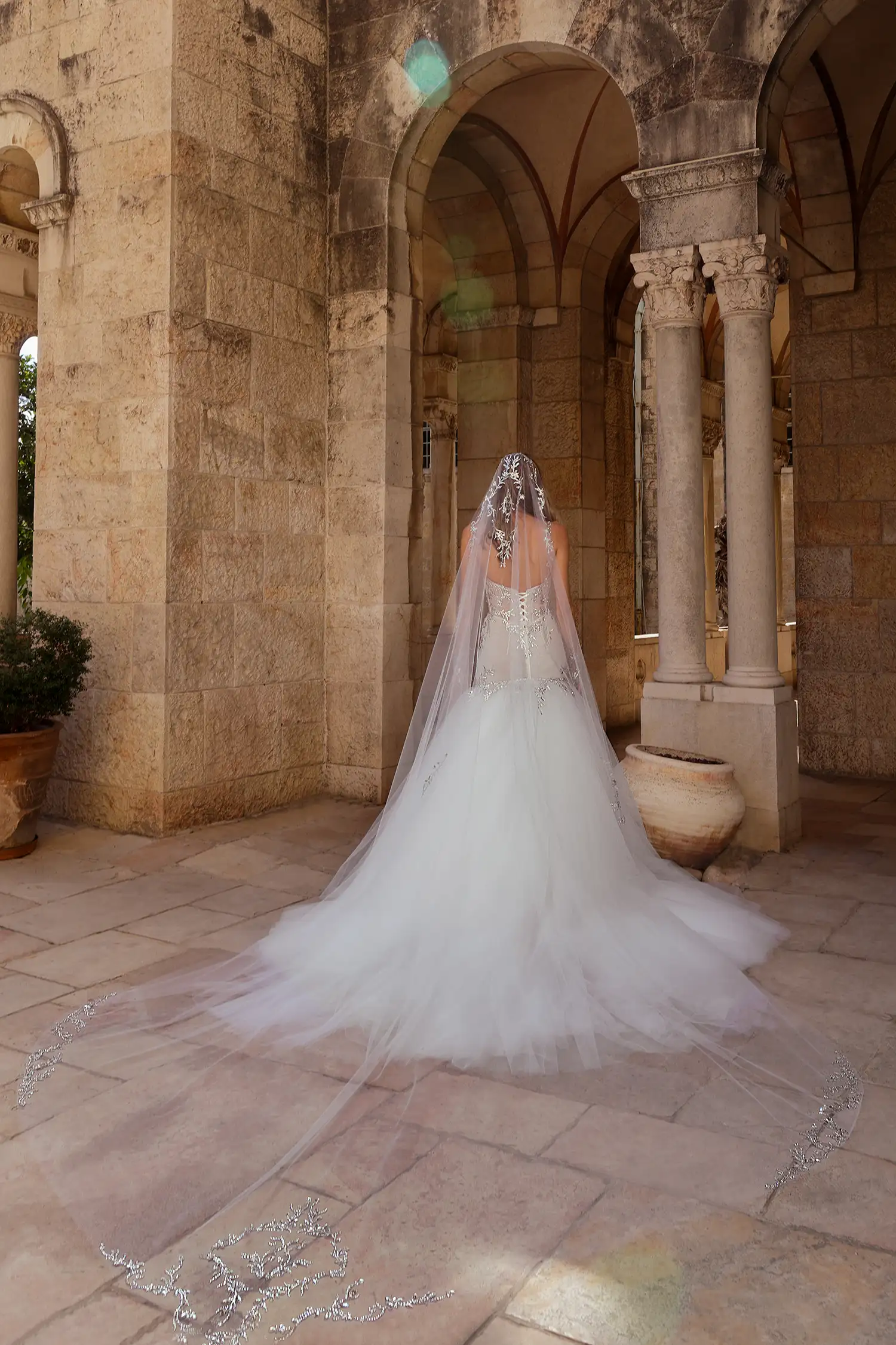 Strapless, sweetheart mermaid gown in tulle plissé fully embellished in mirror crystals. Shown with mirror crystal appliqué illusion gauntlet gloves and cathedral-length mirror crystal mantilla veil.