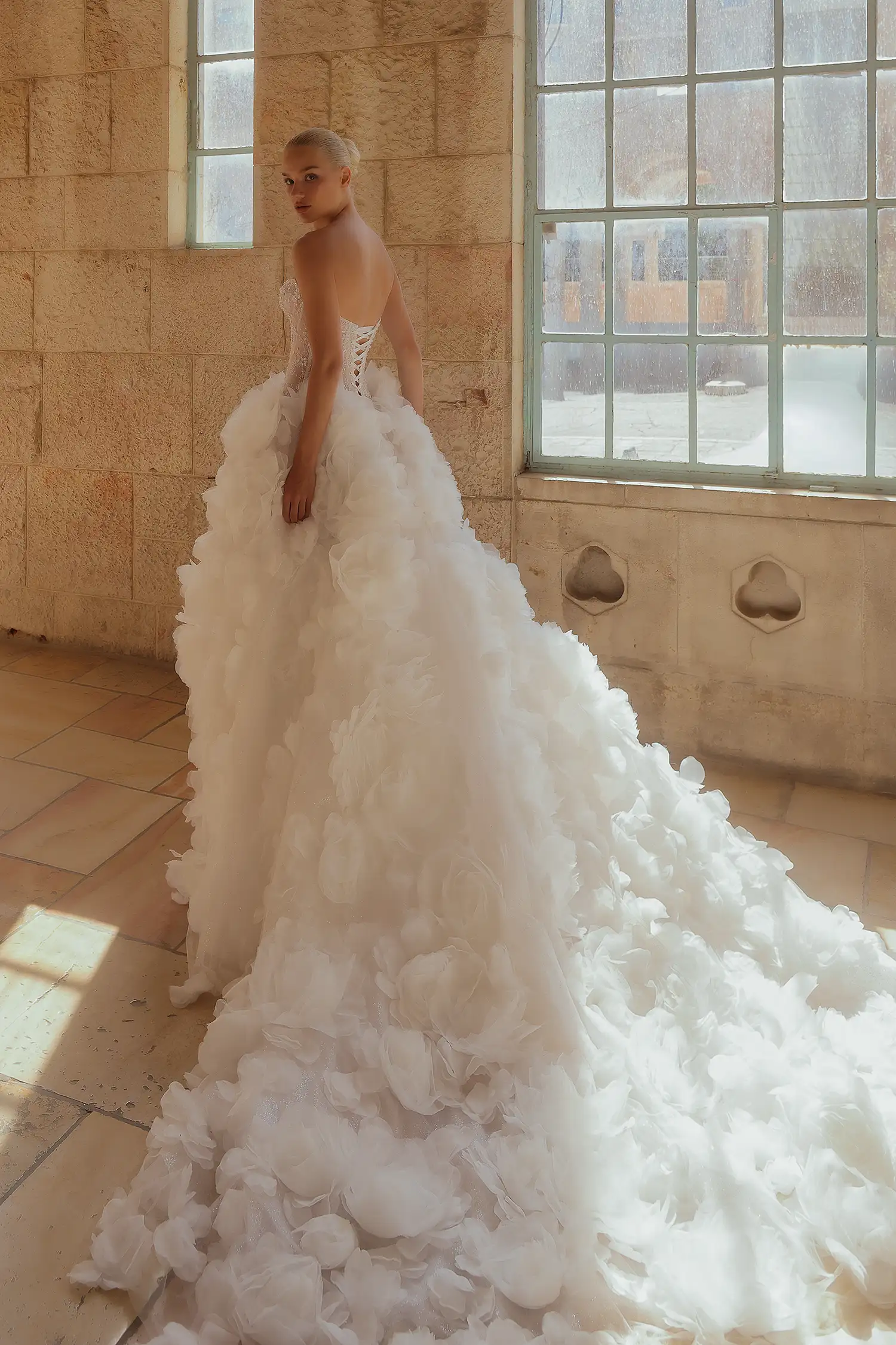 Strapless ballgown with hand-beaded chantilly lace corset with water crystal neckline detail and dimensional organza flower skirt.