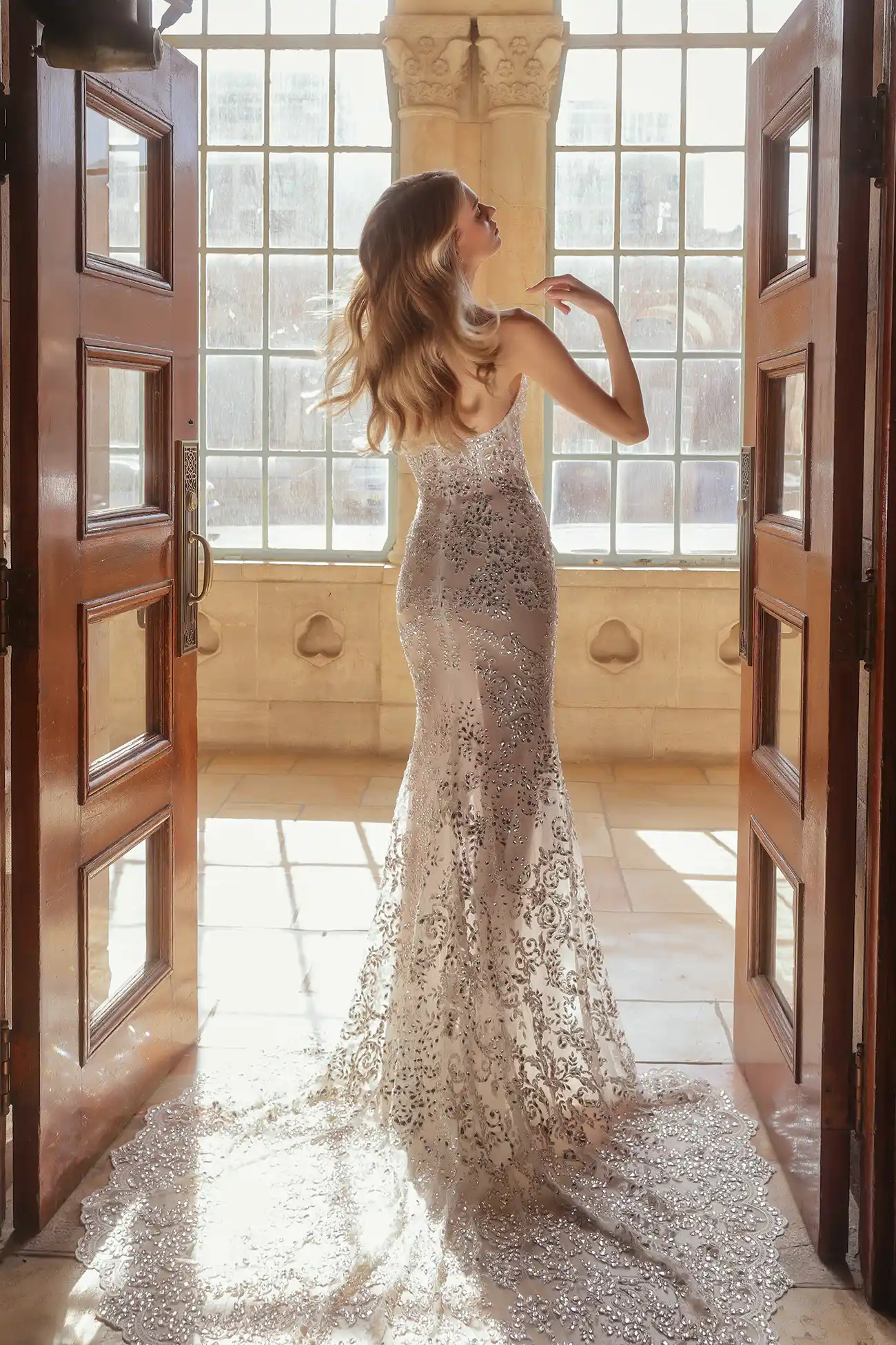 Strapless embroidered lace sheath gown fully hand beaded with mirror crystals, shown with cathedral-length embroidered lace and mirror crystal mantilla veil.