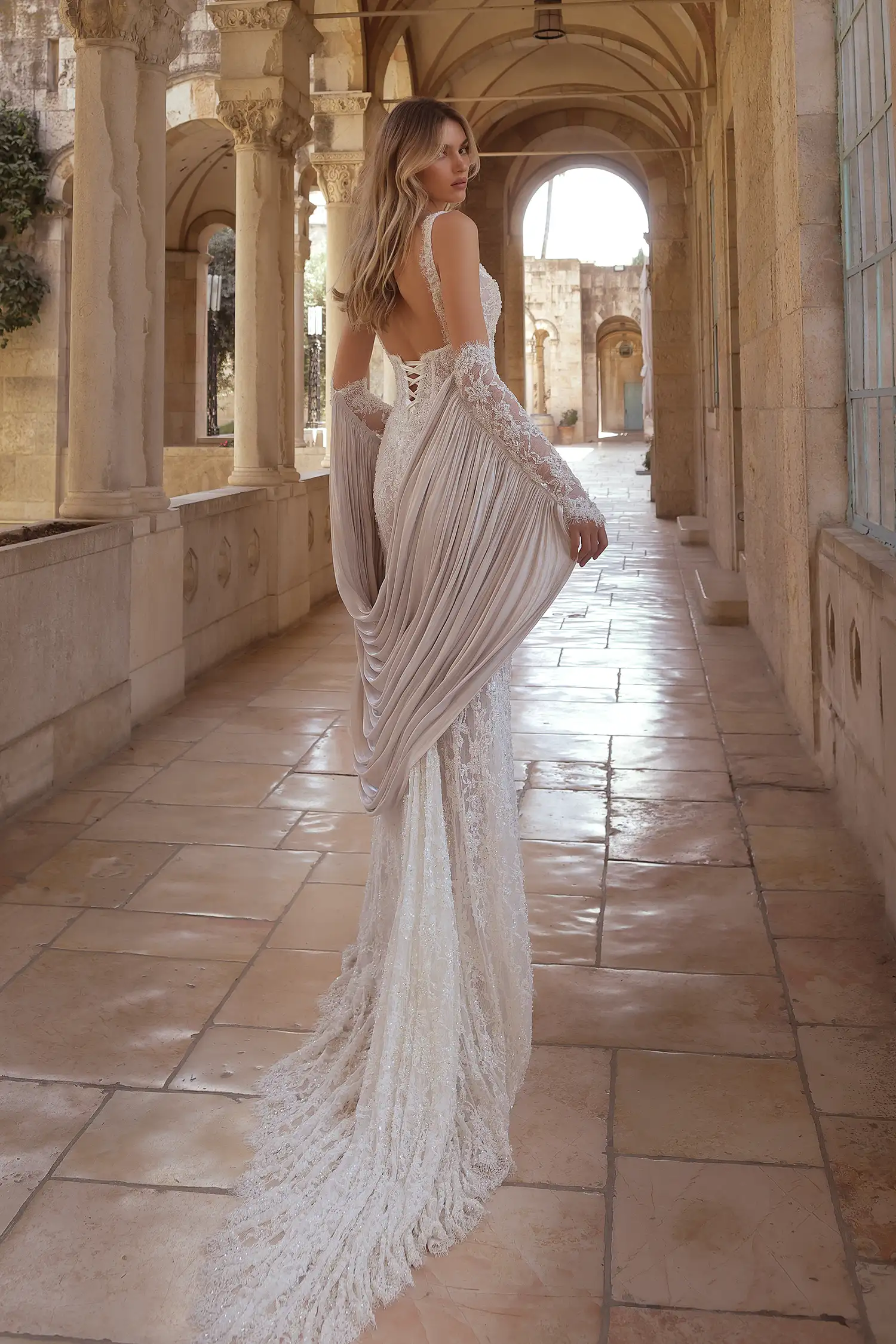 Beaded chantilly lace sheath gown with plunging neckline and underbust basque waist corset with exposed boning. Shown with beaded chantilly lace gauntlet gloves with draped liquid organza cape.