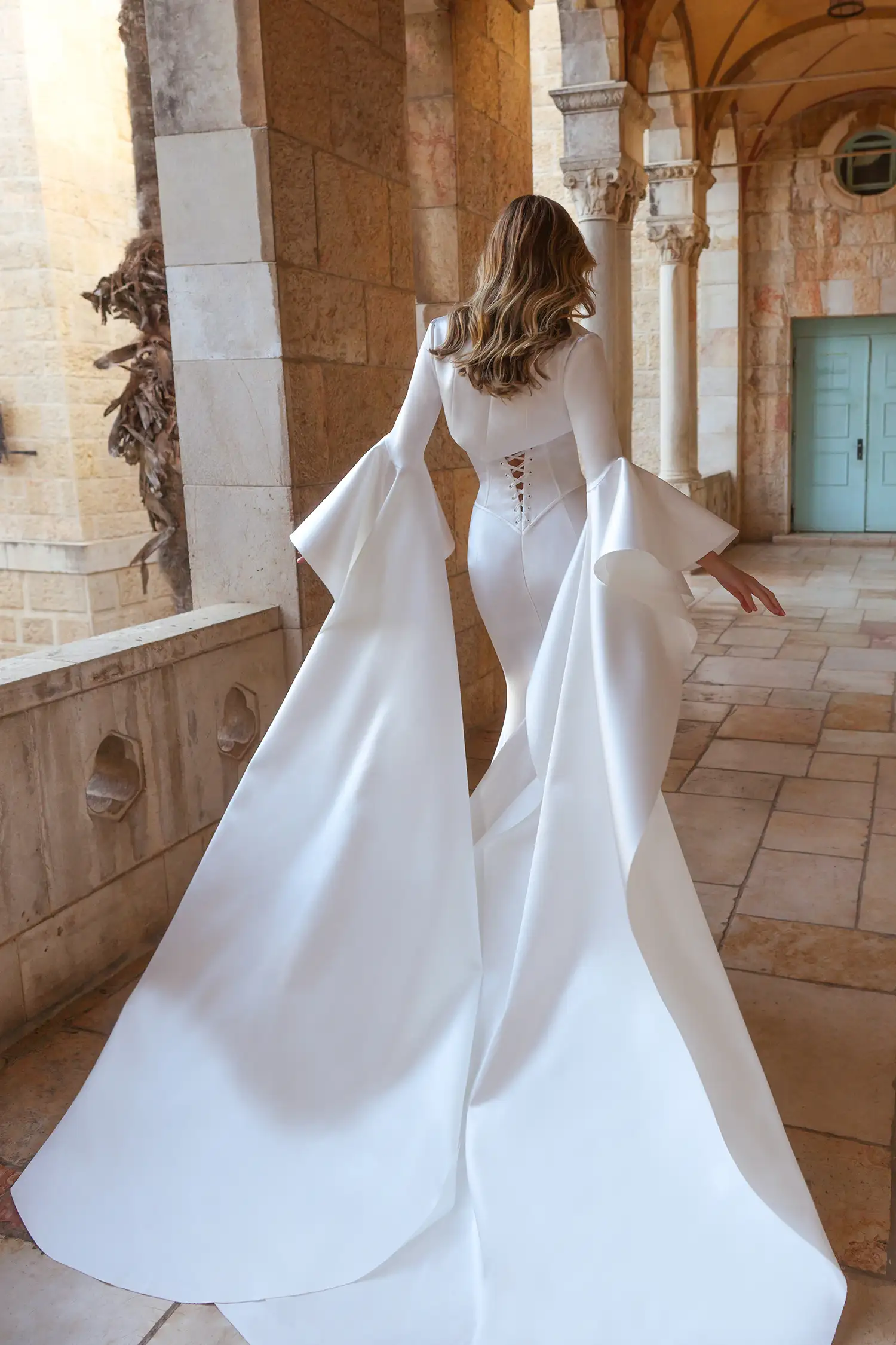 Strapless doubleface satin fit-and-flare gown with basque waist corset, shown with high collar doubleface satin bolero with dramatic floor-length sleeves. 