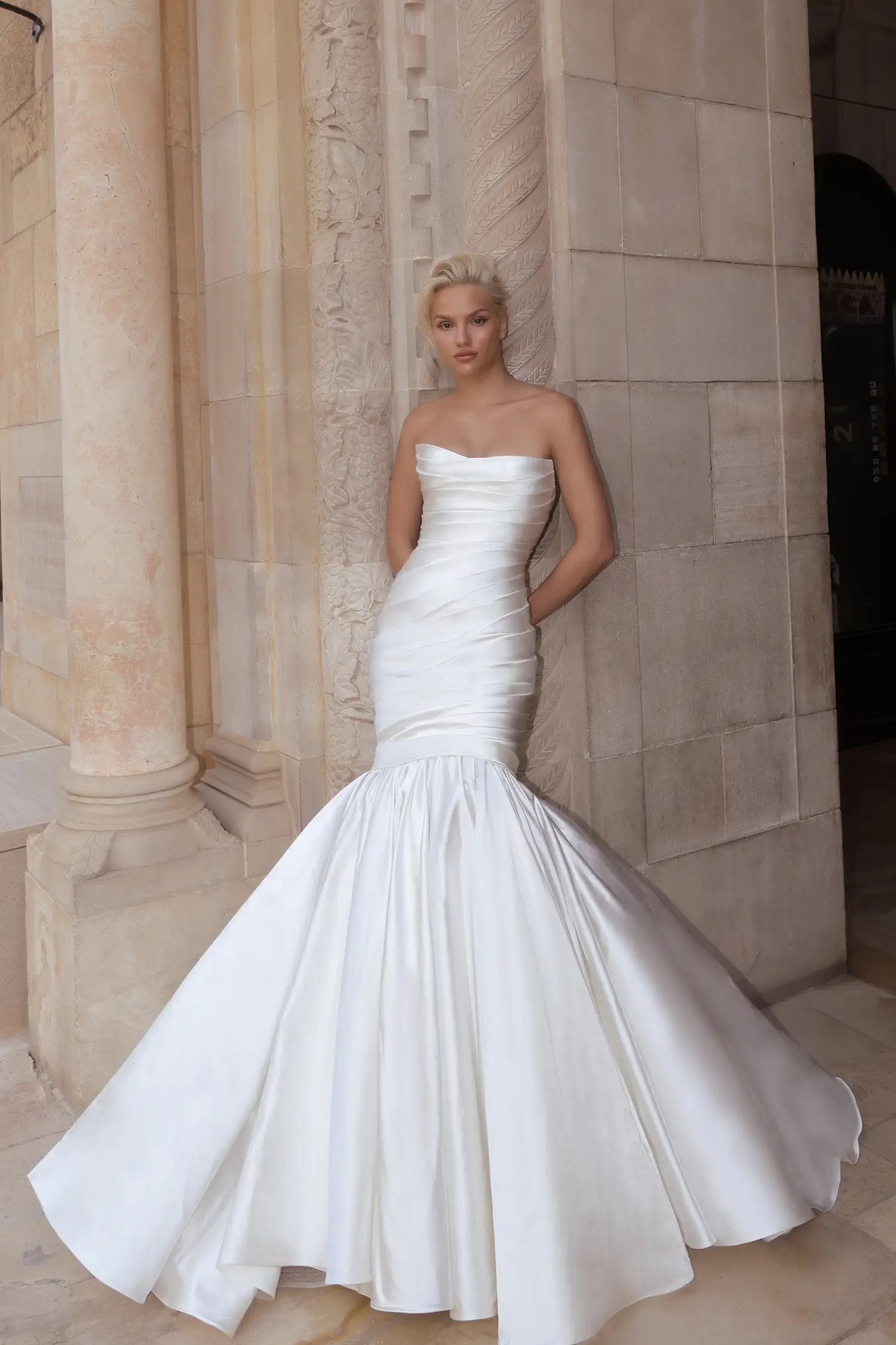 Draped strapless, straight-neckline mermaid gown in silk satin with signature Pnina bow.