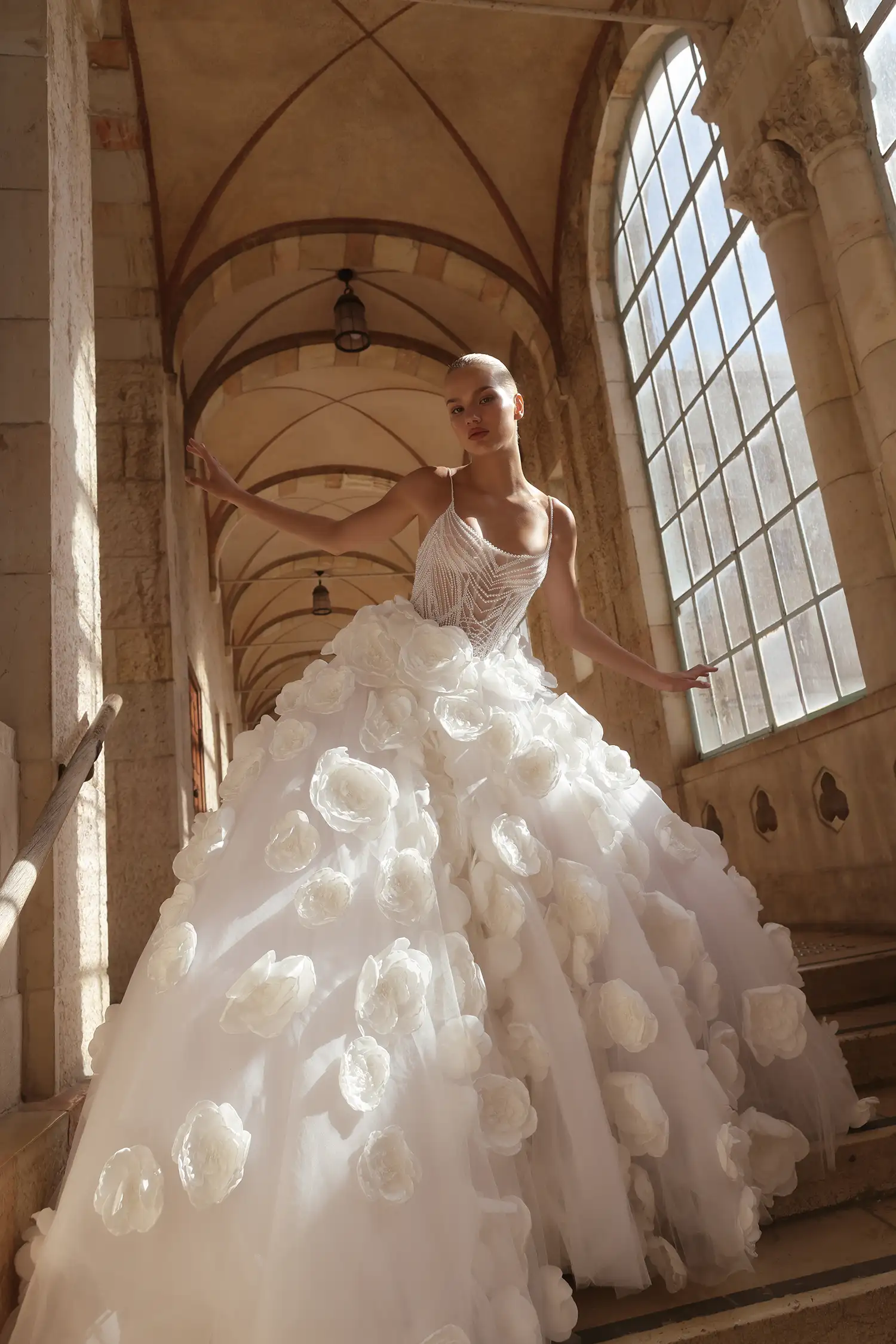 Ballgown with hand-beaded pearl bodice, satin dimensional flower skirt with pearl details, and pearl off-the-shoulder straps.