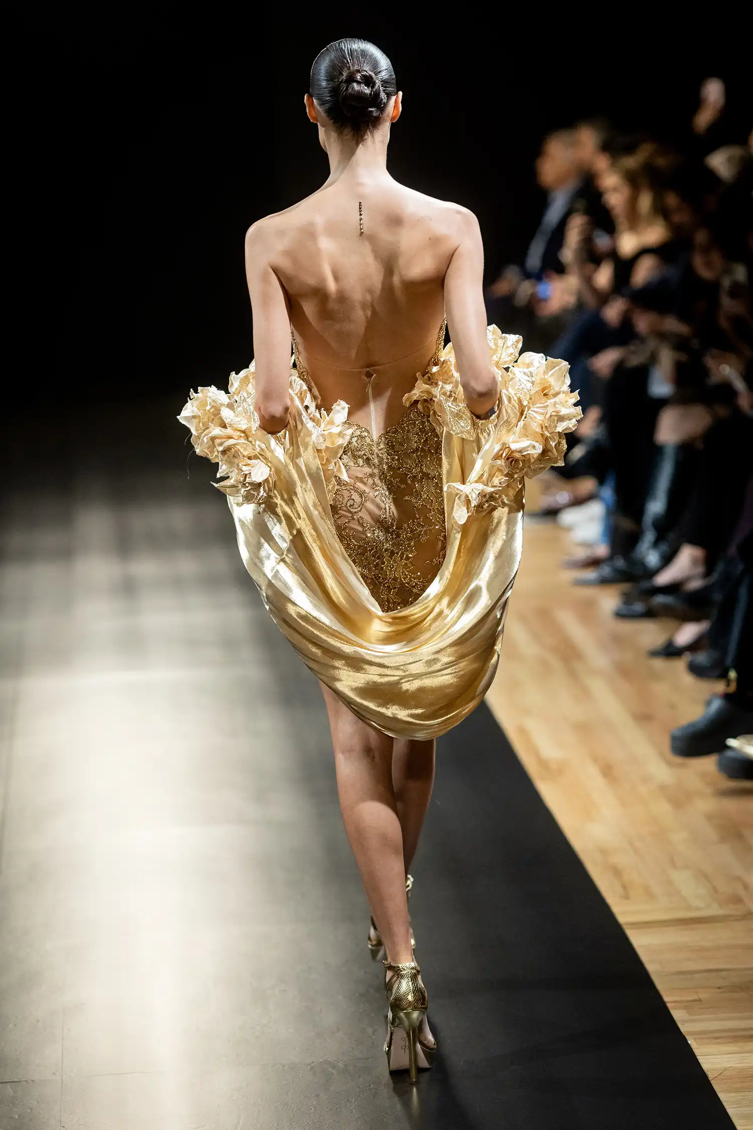 Strapless minidress in gold metallic chantilly lace, fully hand-embellished in gold crystals. Shown with liquid gold stole with handmade dimensional roses.