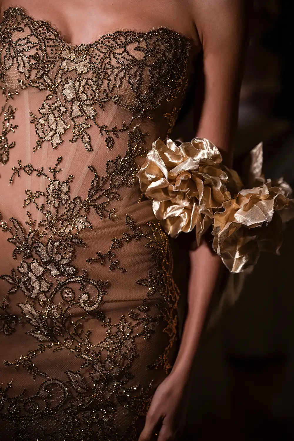 Strapless minidress in gold metallic chantilly lace, fully hand-embellished in gold crystals. Shown with liquid gold stole with handmade dimensional roses.
