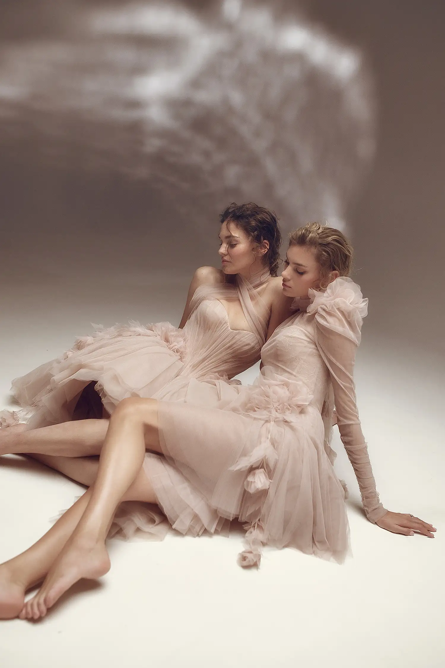 Blush pink high neck soft tulle minidress with chantilly lace sweetheart bodice, gathered tulle long sleeves, and dimensional organza flower and hanging vine details.