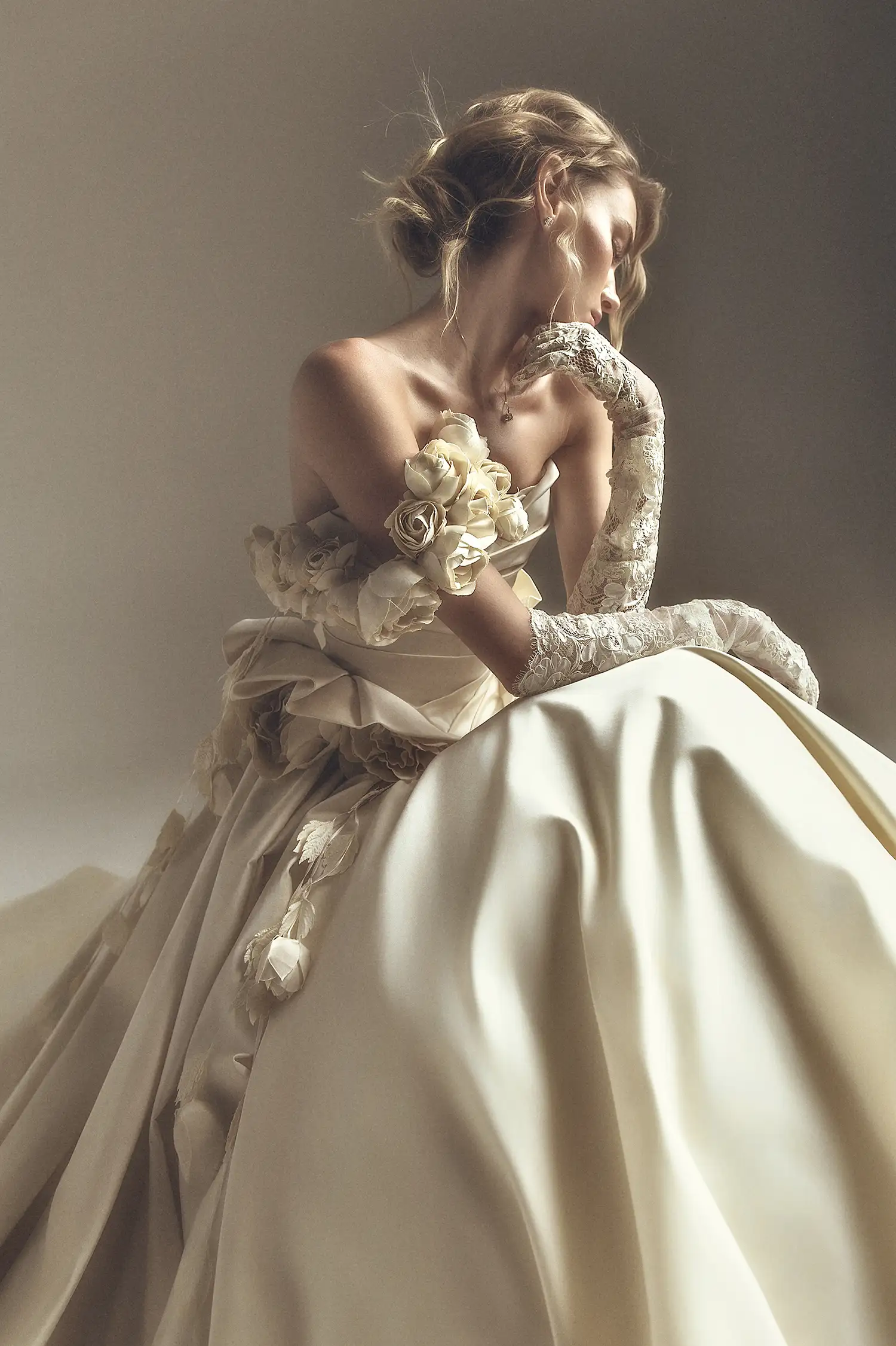 Strapless satin ballgown with draped bodice, ruffled basque, and handmade satin roses at neckline and waist.