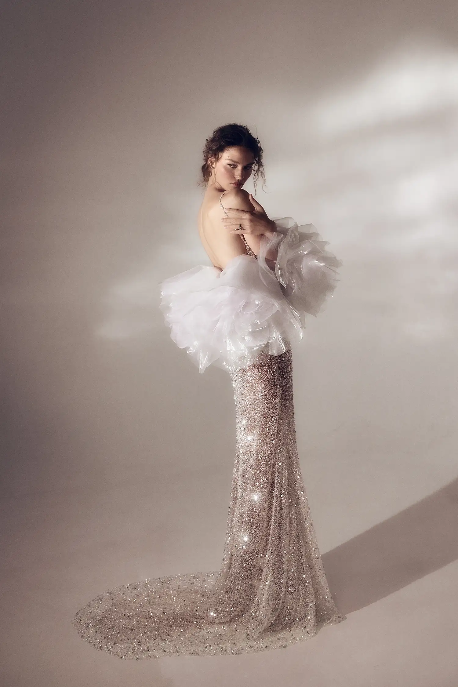 Fully-beaded silver crystal and sequin sheath gown with square neckline and open back, shown with iridescent organza handmade flower stole.