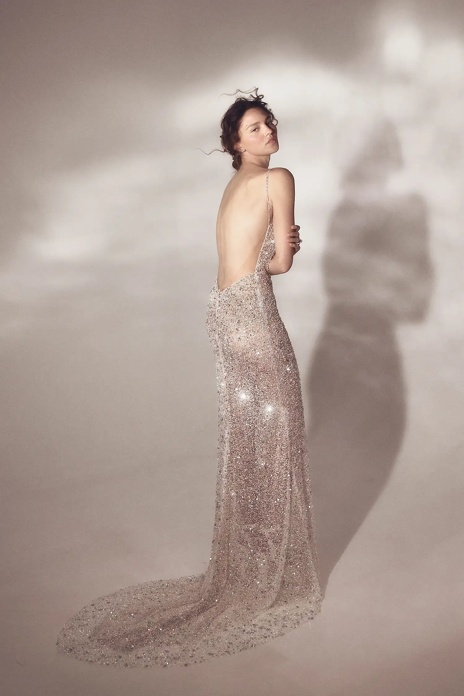 Fully-beaded silver crystal and sequin sheath gown with square neckline and open back, shown with iridescent organza handmade flower stole.