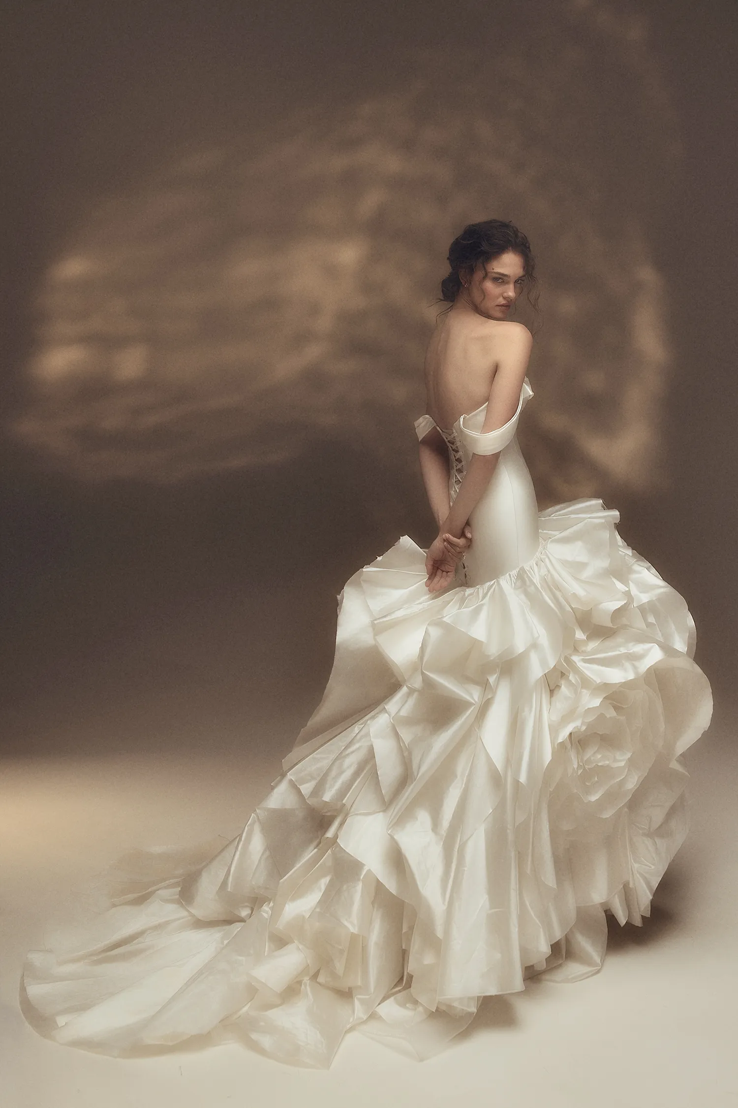 Off-the-shoulder sweetheart drop waist gown in pearl taffeta with dramatic ruffle and handmade rose skirt.