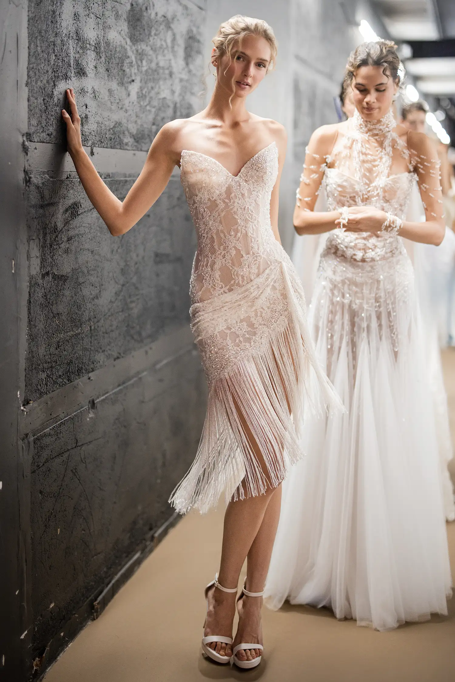 Strapless corseted minidress in hand-beaded chantilly lace with beaded fringe and draped lace details.