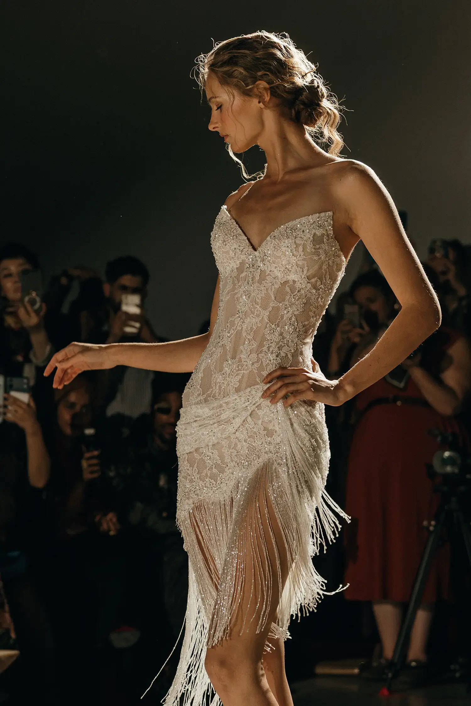 Strapless corseted minidress in hand-beaded chantilly lace with beaded fringe and draped lace details.