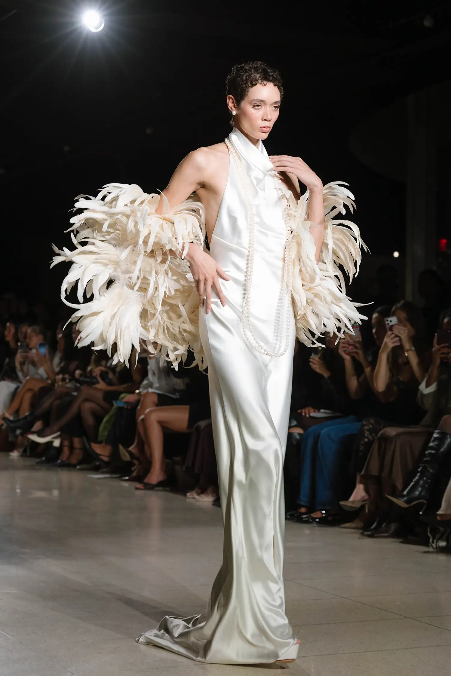 Bias cut satin halter gown with low back, shown with rooster feather boa.