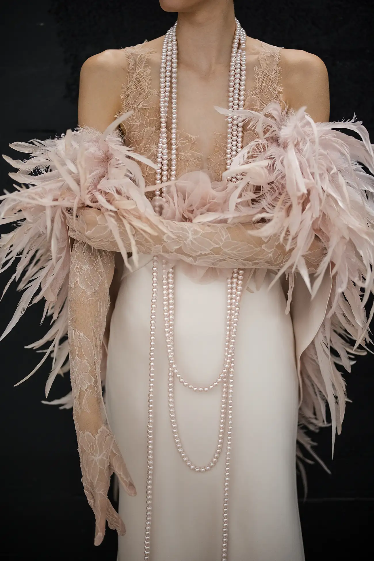 Blush satin bias cut sheath gown with chantilly lace bodice and dimensional organza flower detail, shown with blush pink rooster feather stole.