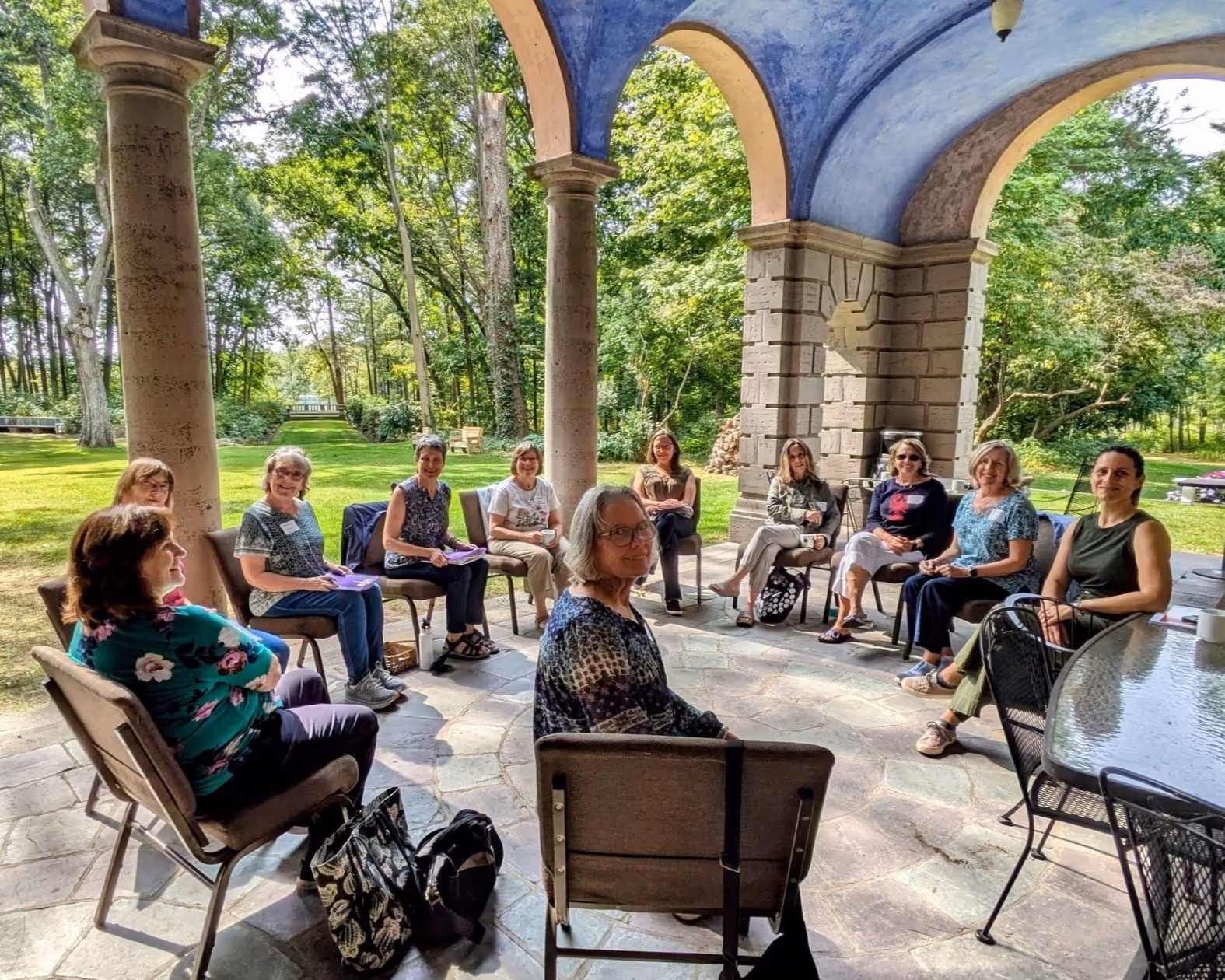 A group of participants sitting in a circle near the arches of the Tyson patio