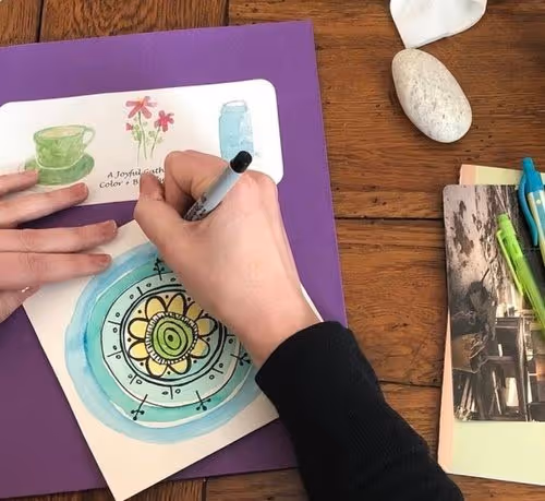 A participant in an art and spirituality workshop paints on a small canvas