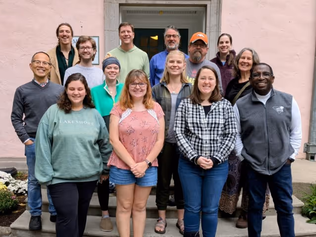 A group of retreat participants gather for a group photo in front of the Rolling Ridge front steps