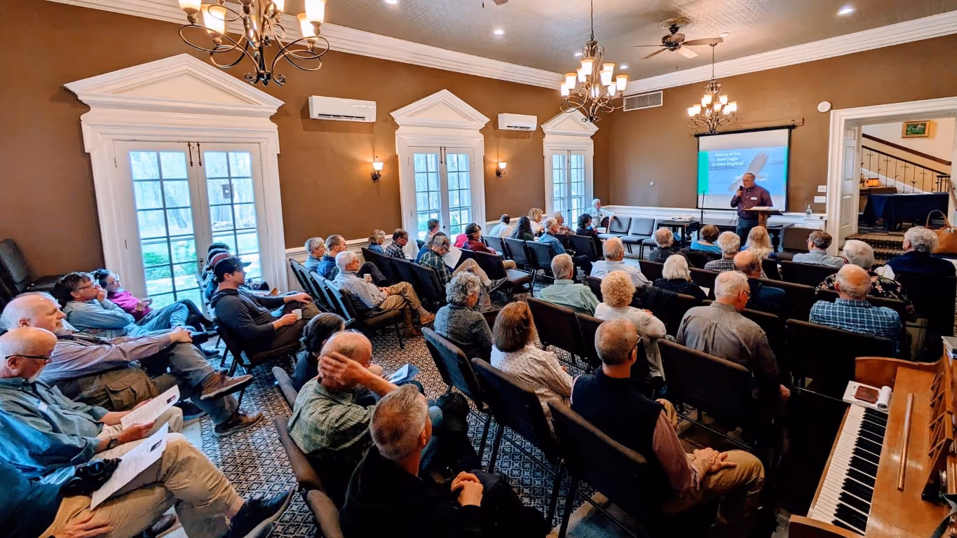 A large group sits and listens to a presentation in Tyson Hall
