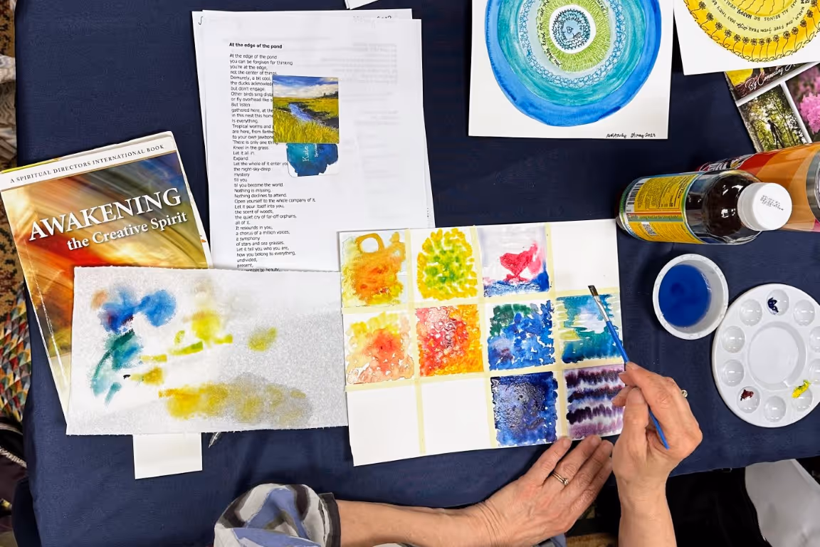 A retreat participant does watercolor paints during an art and spirituality workshop