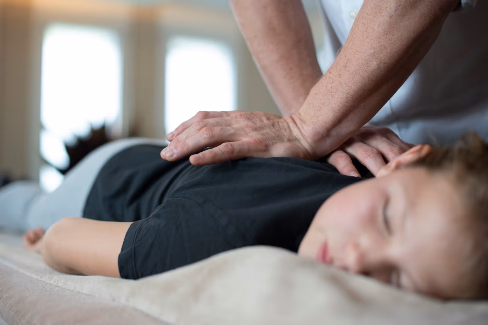 A person in a gray shirt receiving a massage. Stock photo by Edward Muntinga from Unsplash.com