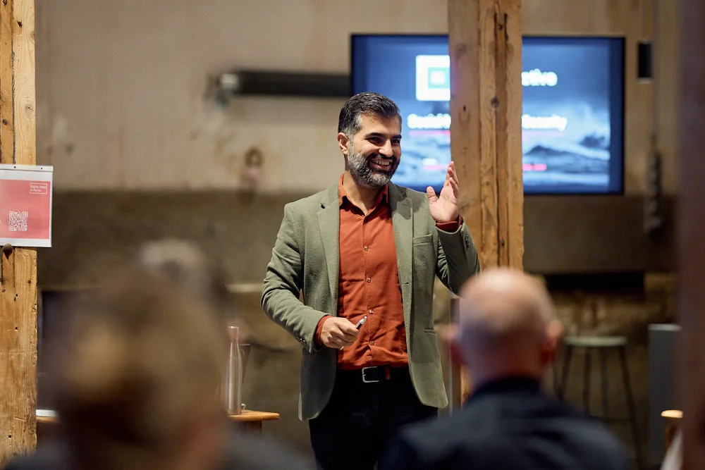 Ein Mann hält lächelnd eine Präsentation.