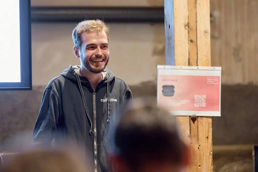 Ein Mann hält lächelnd eine Präsentation.