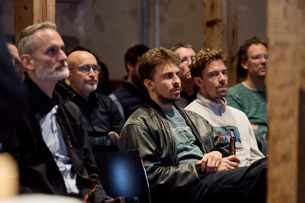 Menschen im Publikum hören gespannt zu.