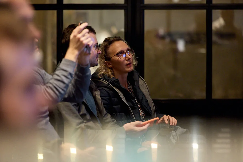 Menschen im Publikum hören gespannt zu.