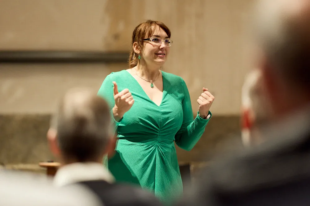 Eine Frau spricht lächelnd vor einem Publikum.