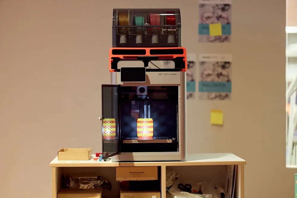 Ein 3D-Drucker steht auf einem Tisch und produziert etwas.