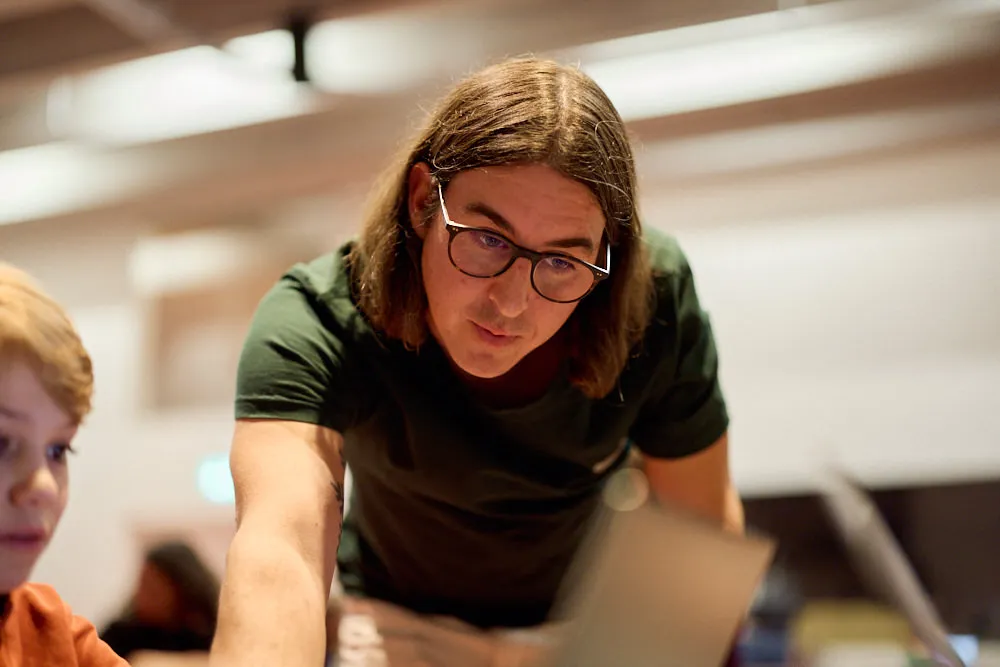 Ein Mann bedient konzentriert einen Laptop.