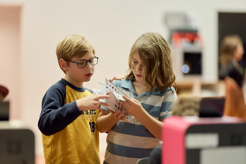 Zwei Kinder schauen zusammen durch ein Heft.