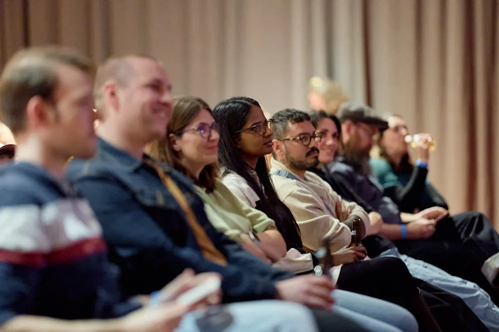 Menschen im Publikum hören gespannt zu.