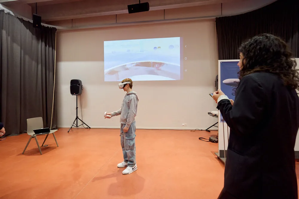 Ein Junge testet eine VR-Brille in einem Raum mit Controller in der Hand.