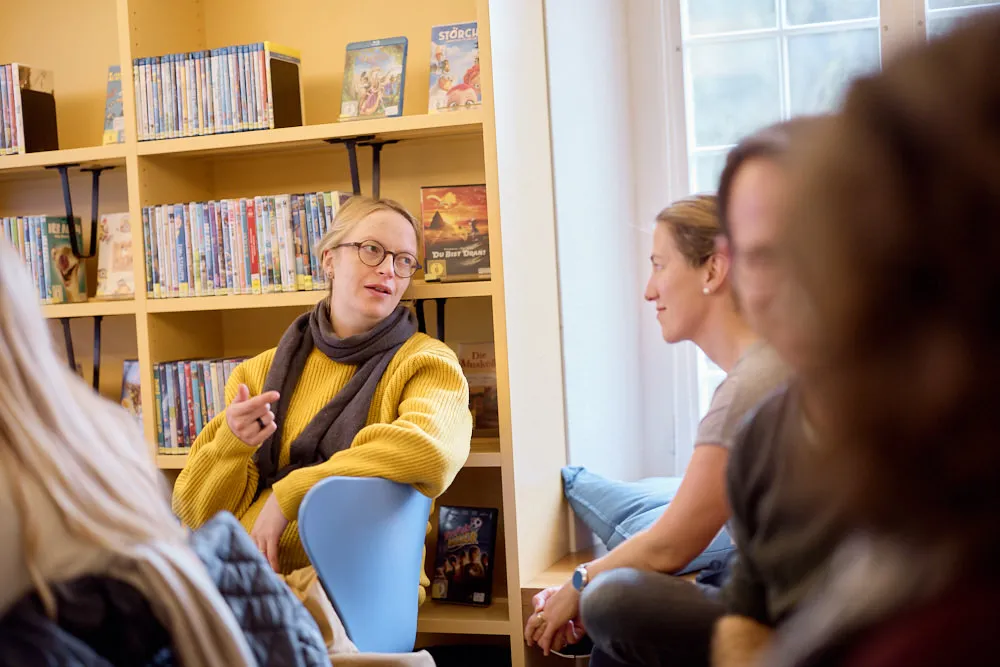 Zwei Frauen im Publikum in der Bibliothek sprechen miteinander.