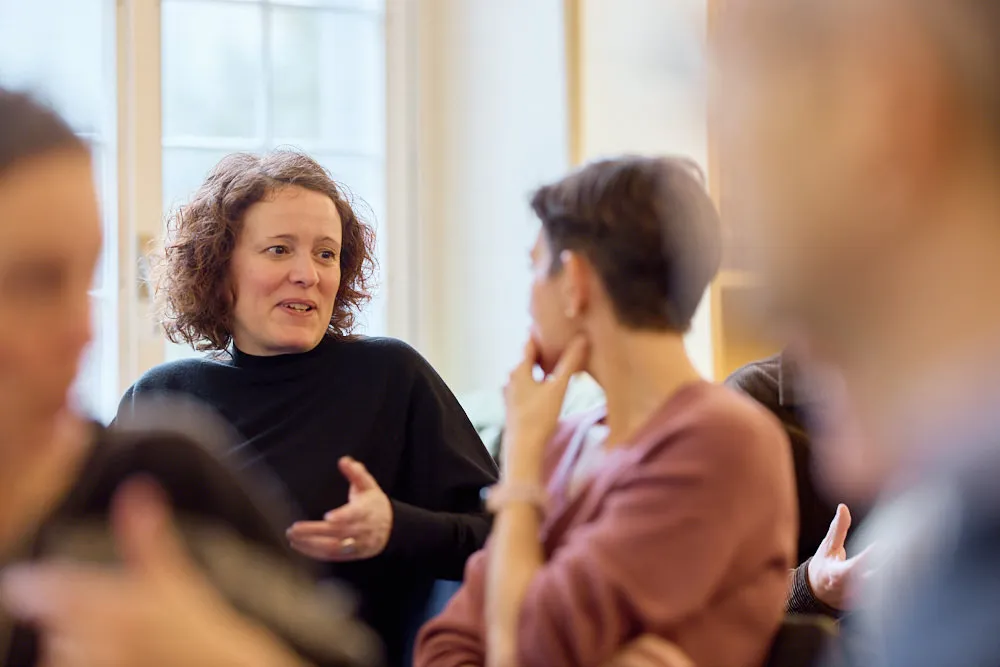 Zwei Frauen im Publikum sprechen miteinander.