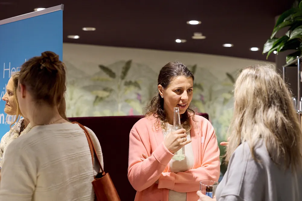 Im Fokus sind zwei Frauen, die miteinander sprechen.
