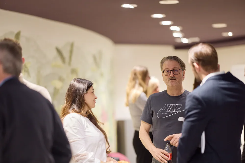 Menschen sprechen in Grüppchen miteinander.