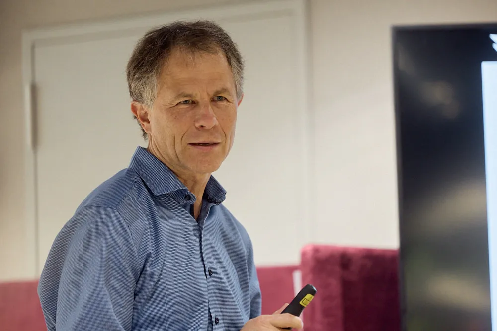 Ein Mann hält eine Präsentation vor einem Bildschirm.