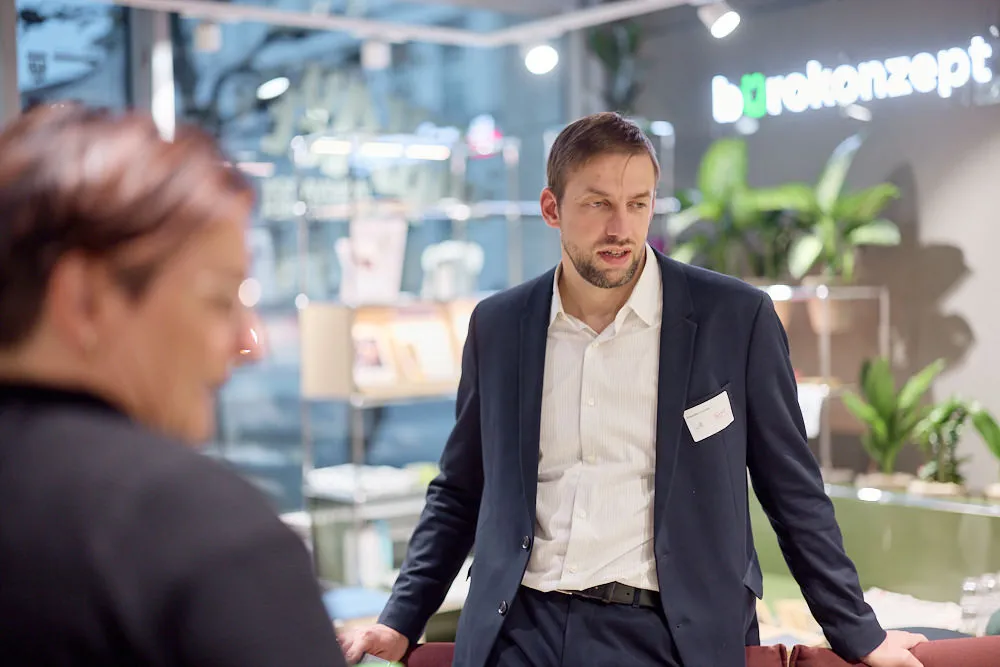 Ein Mann steht in einem Raum vor Pflanzen.