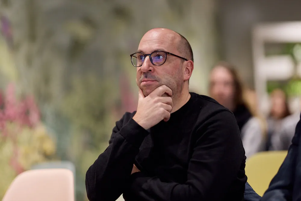 Ein Mann im Publikum hört der Präsentation gespannt zu.