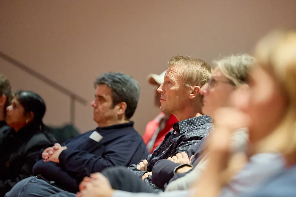 Das Publikum hört gespannt zu.