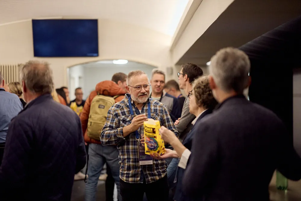 Menschen unterhalten sich stehend und essen Popcorn.
